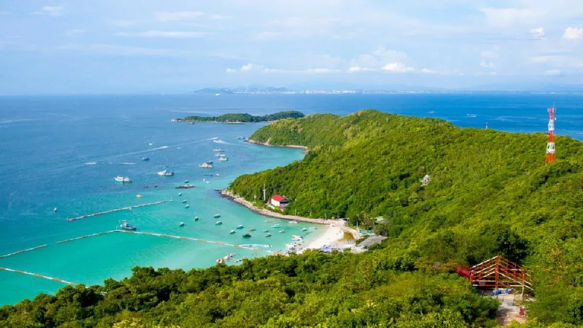 Coral Island's turquoise bay and green hills seen from above